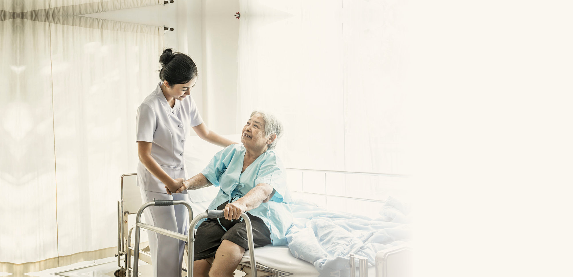 caregiver assisting senior woman to stand