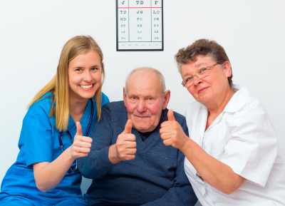 senior man and a two caregiver giving thumbs up